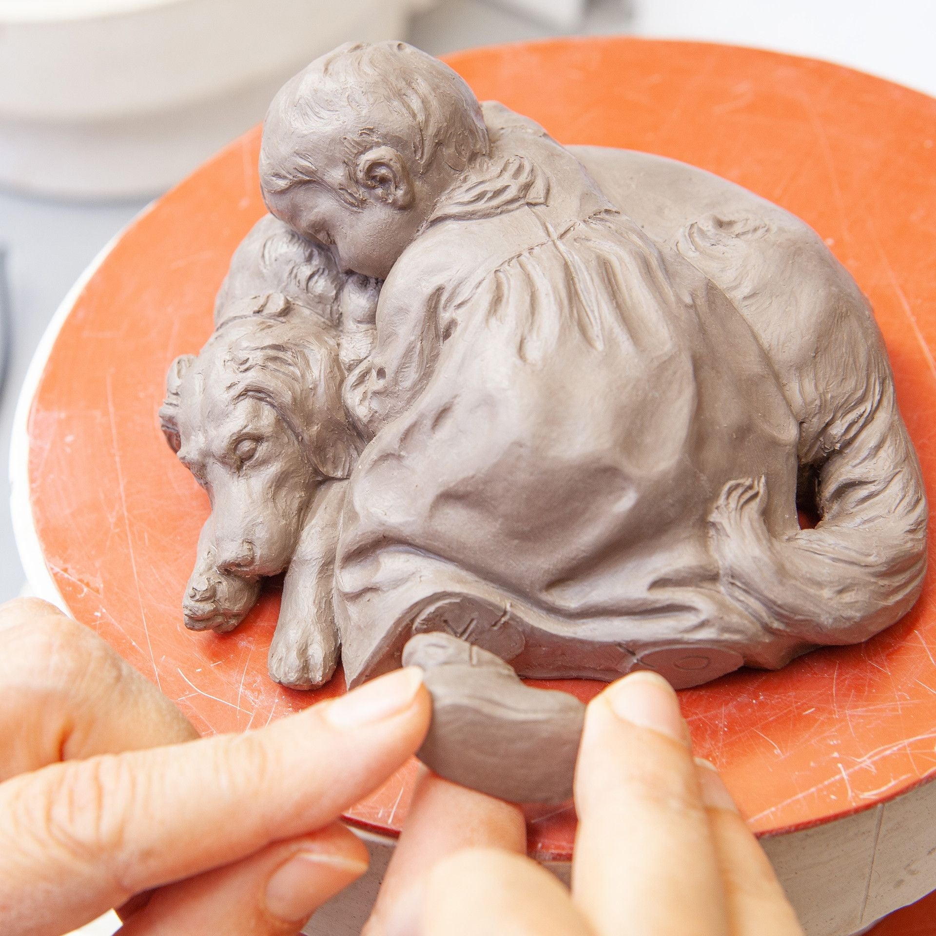 Kind auf Hund liegend, Bunt staffiert mit Blumenkante, L 11 cm | Meissen Miniatur - Hentschelkinder 90A424 - 73754 - Meissen Weimar
